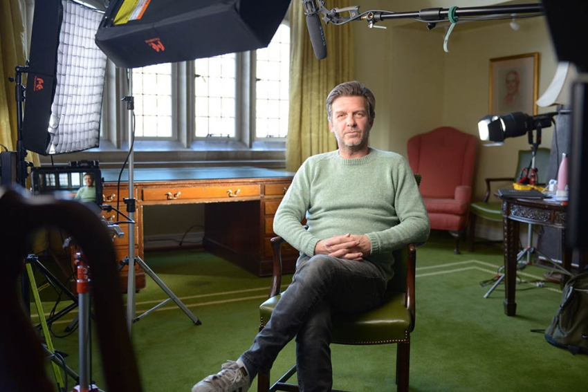 Jason Hughes (Sergeant Ben Jones) sat in a chair looking down a camera whilst waiting to be interviewed